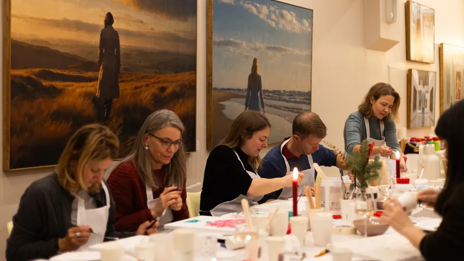 Personen basteln an einem Tisch in einer Galerie.