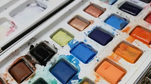 Colorful watercolor palette with various colors.