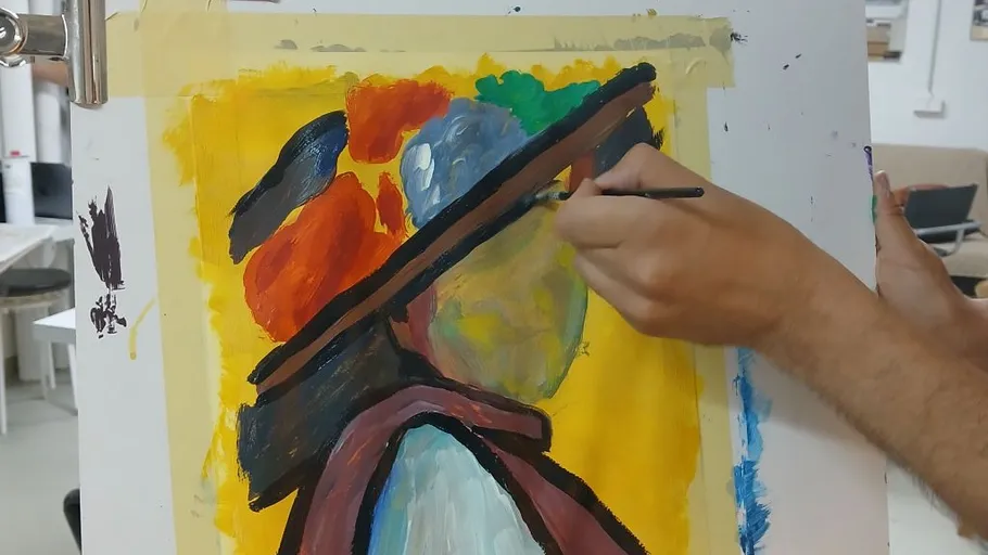 Person painting abstract portrait on canvas.