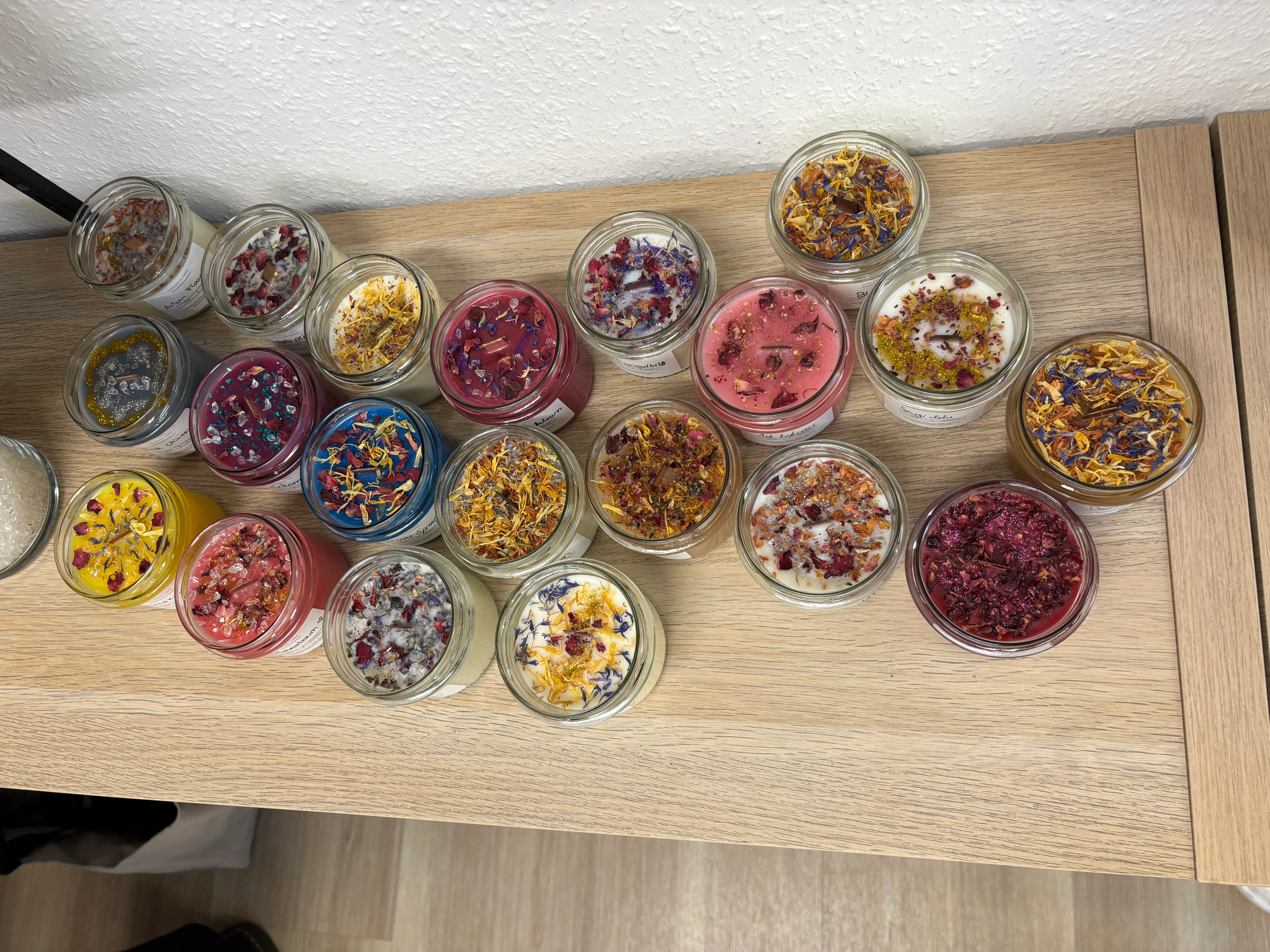 Bunte Kerzen mit Blumen auf Holztisch.