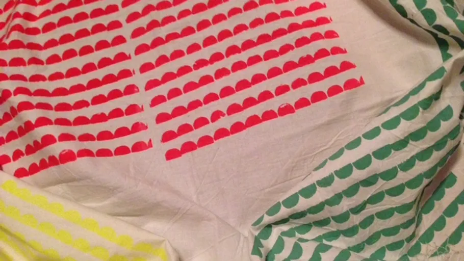 Fabric with colorful semicircle patterns on it.