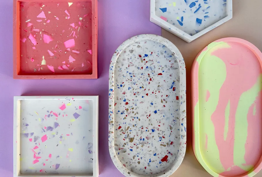 Bunte Terrazzo-Tabletts auf violetter Oberfläche.