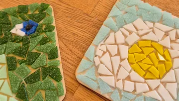 Colorful mosaic pieces on wooden surface.
