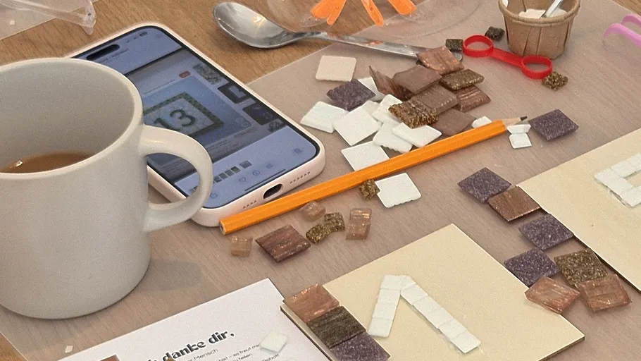 Bastelmaterialien mit Handy und Kaffeetasse.