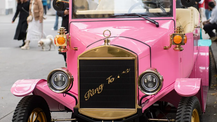 Pink vintage car parked on the street.