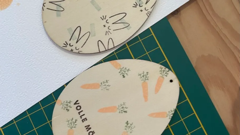 Holz-Ei mit Karottenmuster auf Tisch.