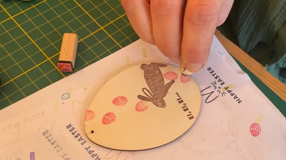Hand stamping an Easter egg decoration.