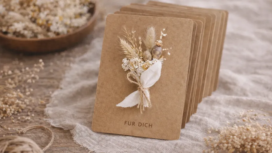 Braune Karten mit Trockenblumen, rustikale Umgebung.