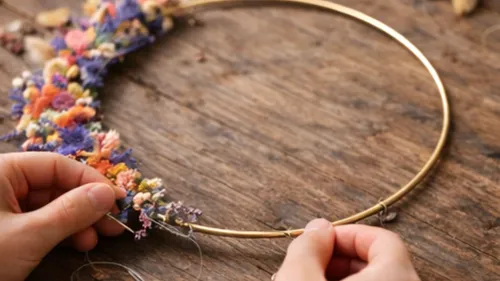 Hände basteln Blumenkranz auf Holztisch.