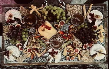 Cheese platter with fruits and dips.