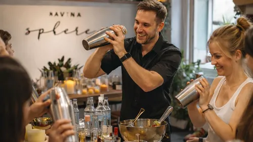 People shaking cocktail shakers in a bar.