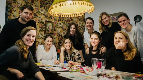 Group of people smiling around a table indoors.
