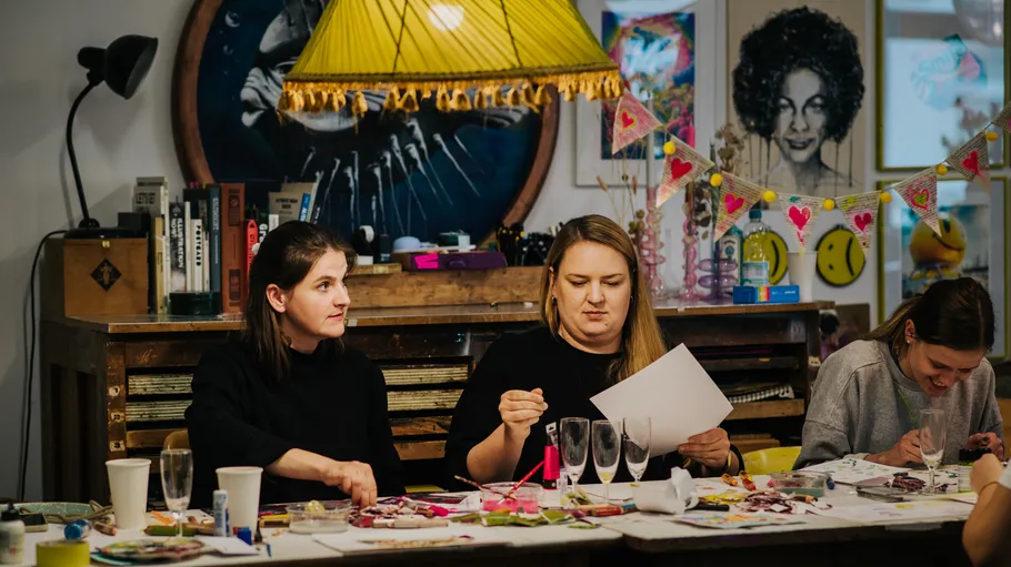 Personen basteln an einem dekorierten Tisch.