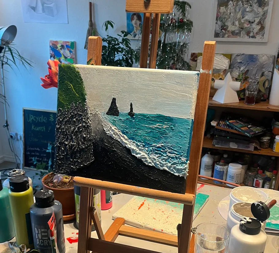 Seascape painting on easel in art studio.