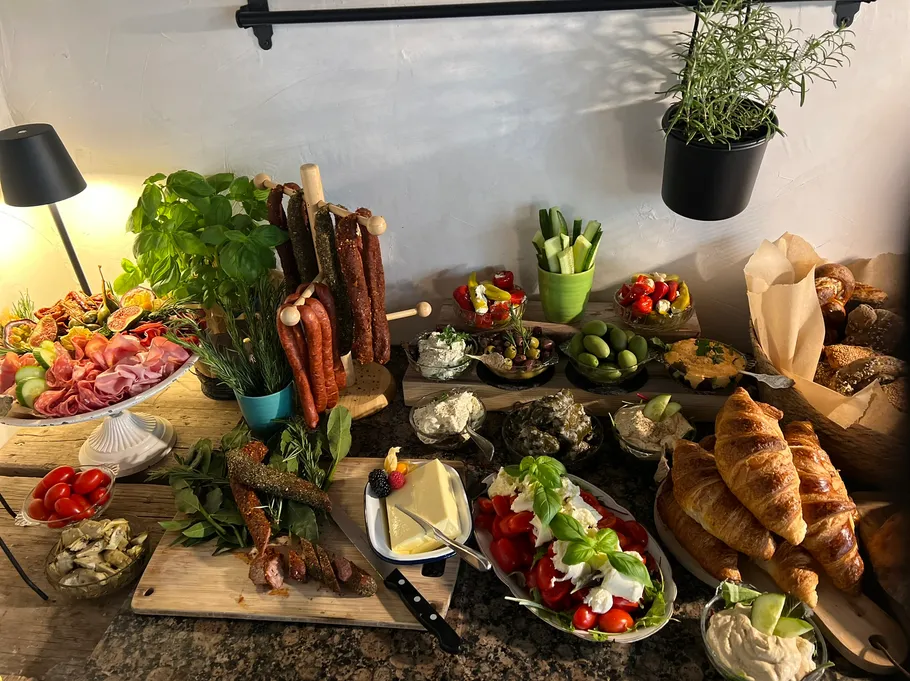 Buffet spread with meats, breads, and vegetables.