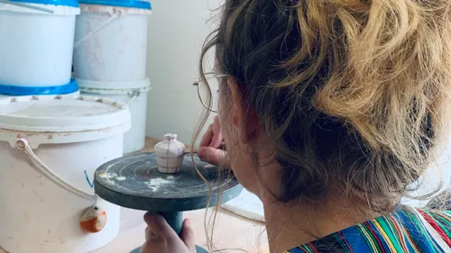 Person bemalt kleine Keramik im Atelier.