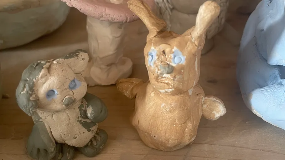 Handmade clay animals on a wooden table.