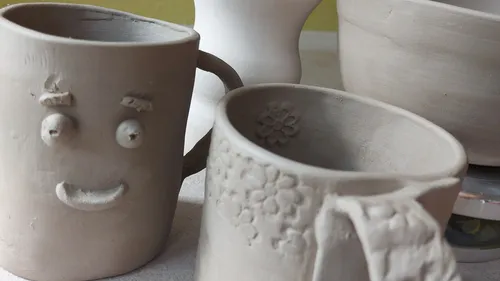 Tonbecher mit Dekorationen auf einem Tisch.