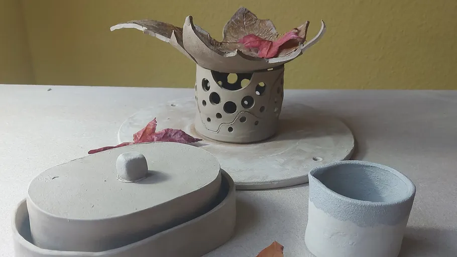 Ceramic holder and pots with dried leaves.