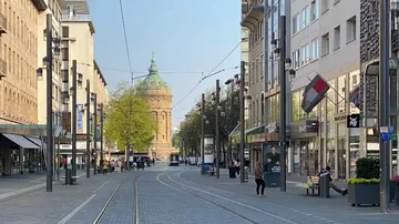 Street with tram tracks and distant tower.