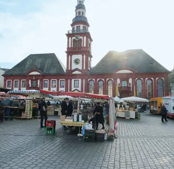 Marktstände vor einem historischen Gebäude.