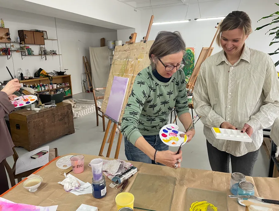 Zwei Frauen malen mit Paletten im Kunststudio.