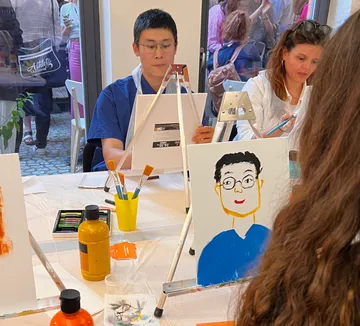 People painting portraits in a studio setting.