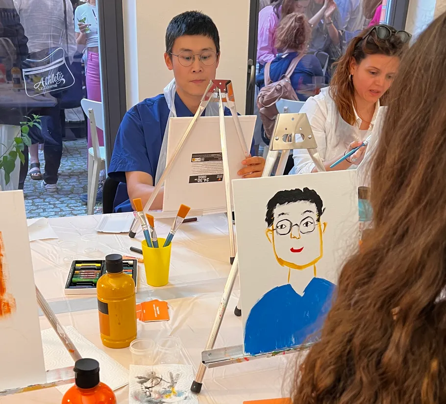 People painting portraits in a studio setting.