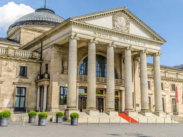 Historisches Gebäude mit Säulen, Eingangsbereich und Treppe.