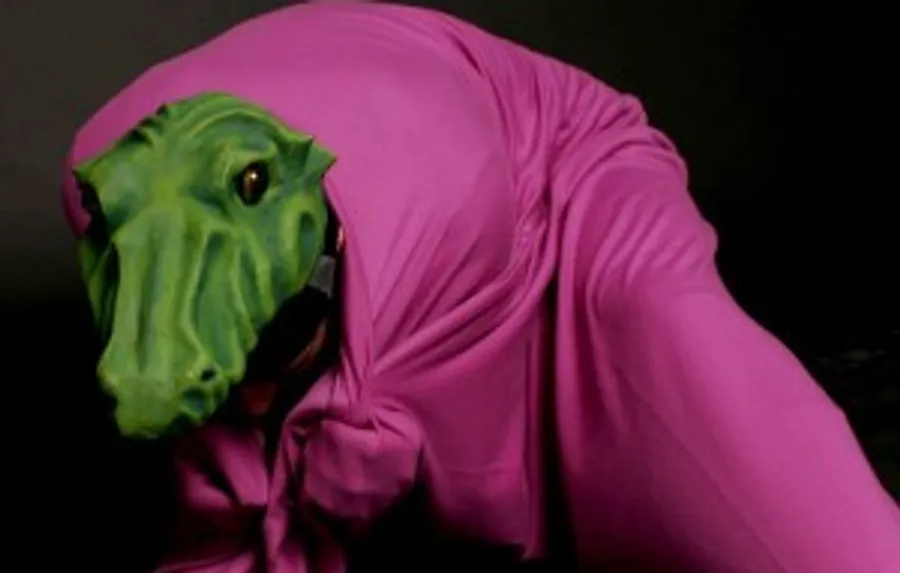 Person in pink suit with green mask, crawling.
