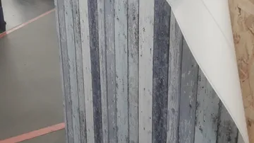 Wallpaper with vertical stripes being peeled.