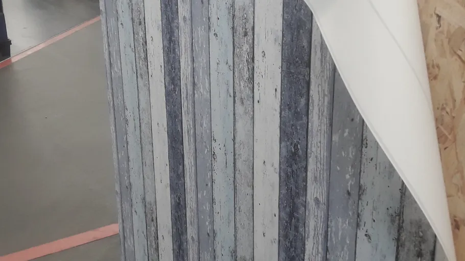 Wallpaper with vertical stripes being peeled.