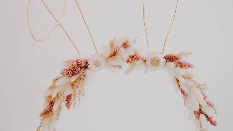 Floral headband with dried flowers on wall.
