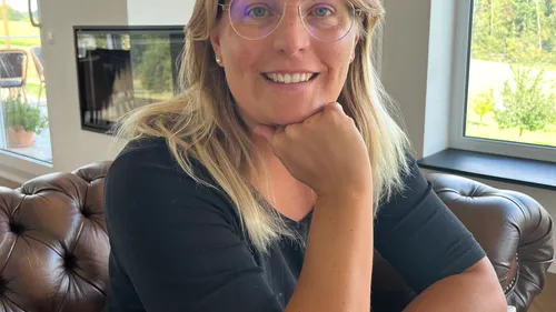 Smiling woman sitting on a leather couch.