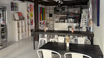 Small cafe with tables and colorful paintings.