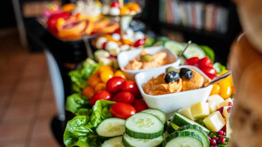 Colorful food platter with vegetables and dips.