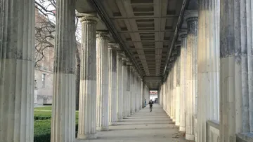 Person geht durch einen Säulengang.