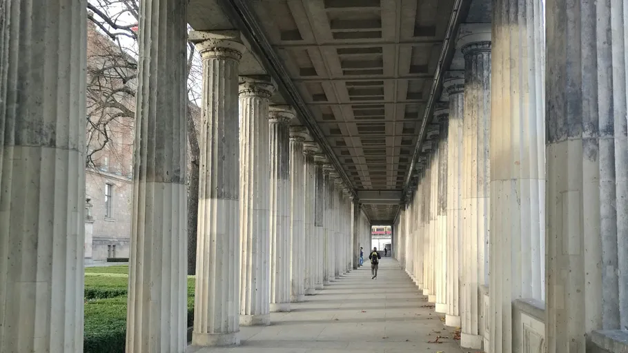 Person walking through columned passageway.