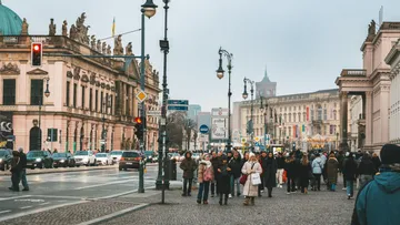 Menschen gehen auf belebter Stadtstraße.