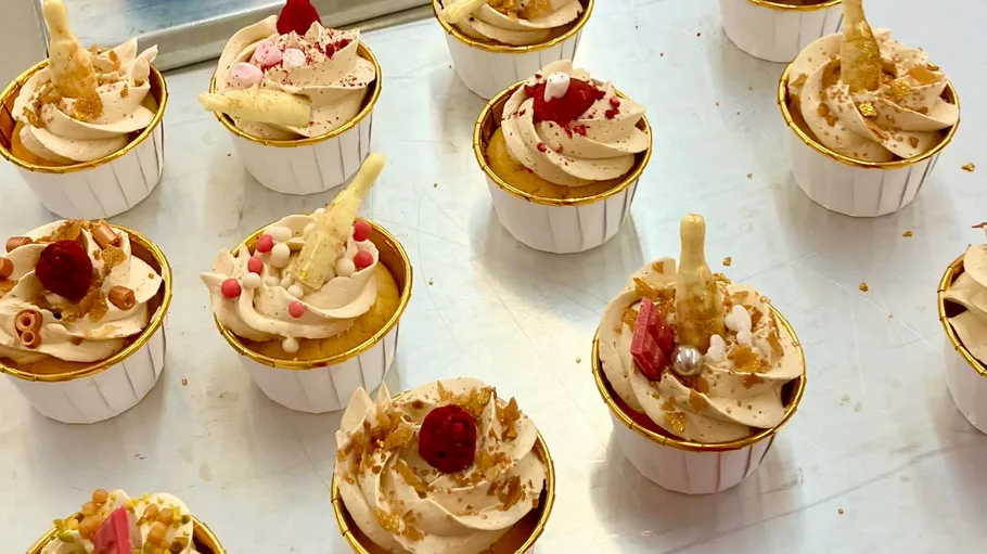 Dekorative Cupcakes mit verschiedenen Toppings auf Tisch.