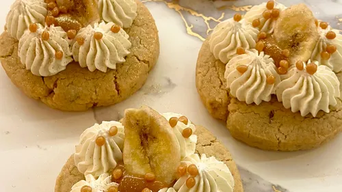 Cookies topped with cream, banana, orange balls.