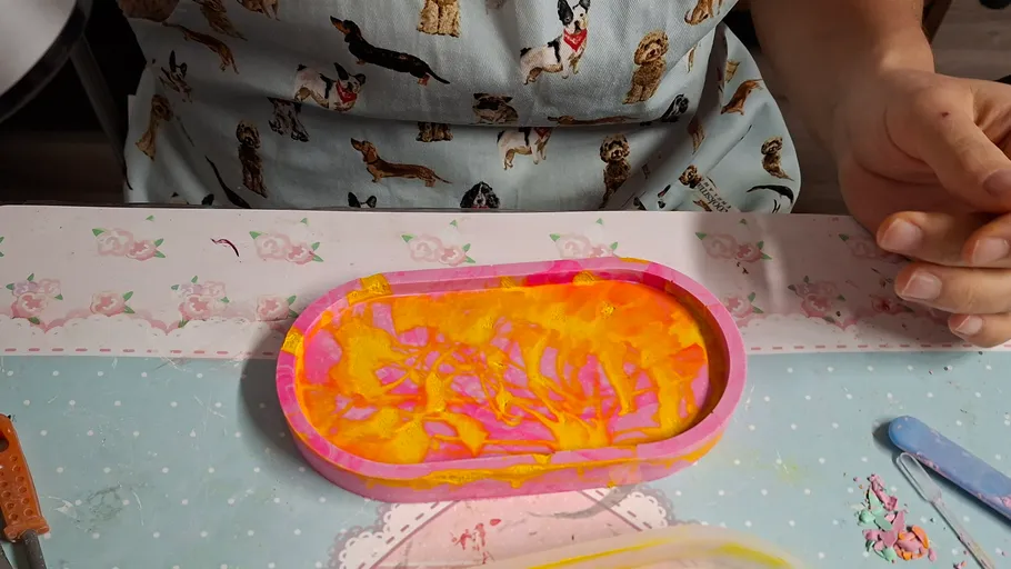 Person crafting with colorful resin mold