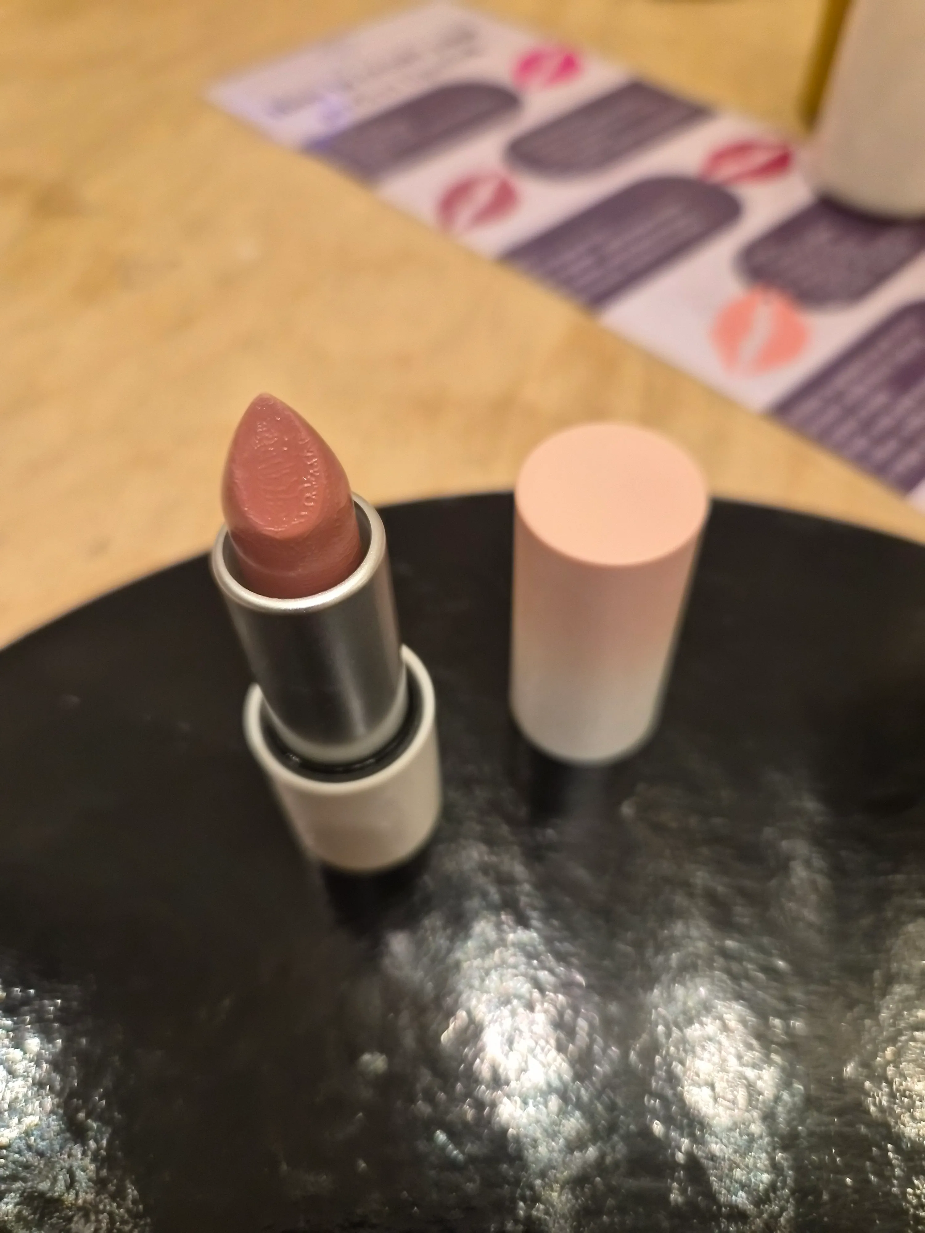 Lipstick on table with advertising leaflet.