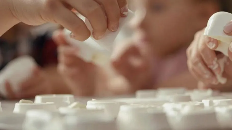 Children's hands playing with molding clay.