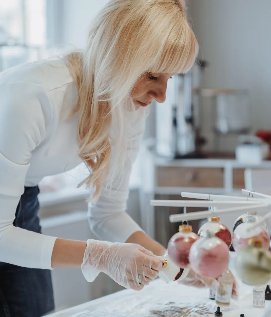 Frau dekoriert Ornamente in Werkstattumgebung.