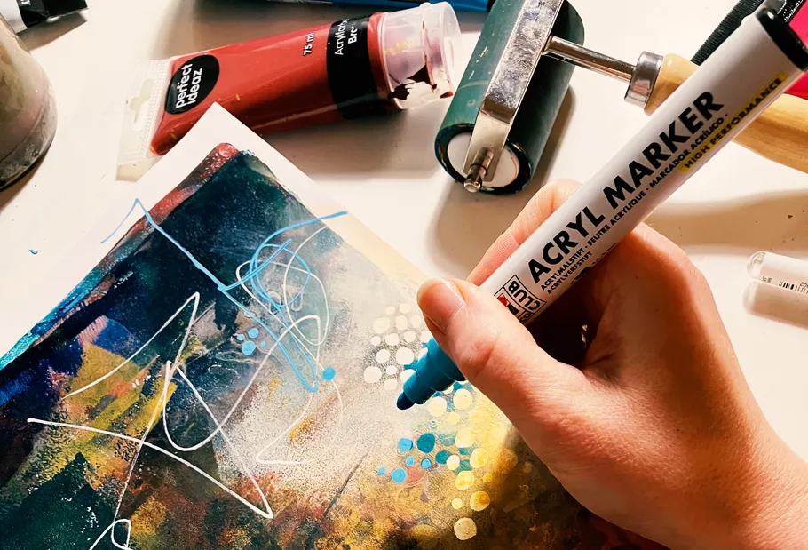 Hand benutzt Acrylmarker auf abstrakter Kunst.