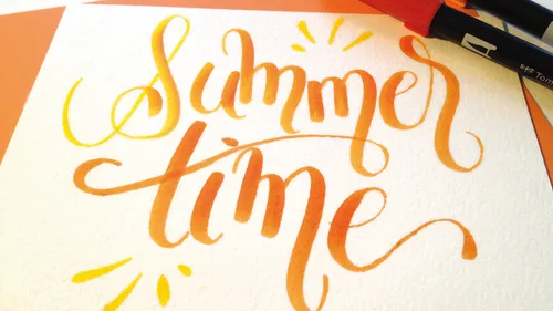 Orange Handlettering mit Schriftzug 'summertime' und Stiften.