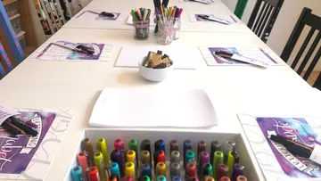 Stifte und Papier auf einem Workshoptisch angeordnet.