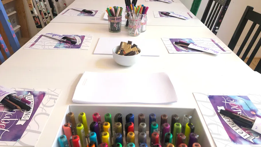 Markers and paper arranged on a workshop table.