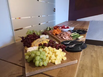 A wooden board with various fruits and snacks.